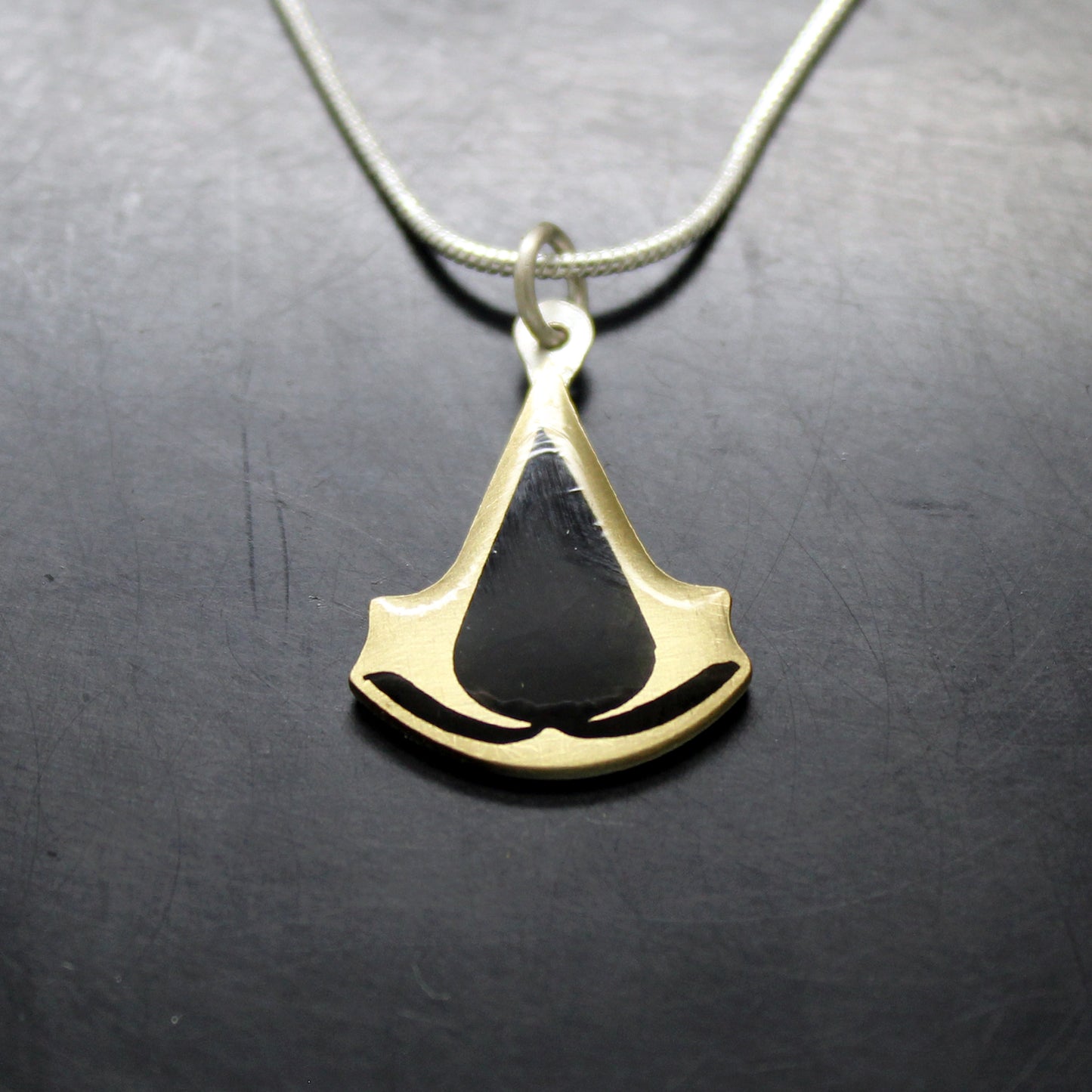 Colgante Assassin's Creed en plata 925 y latón